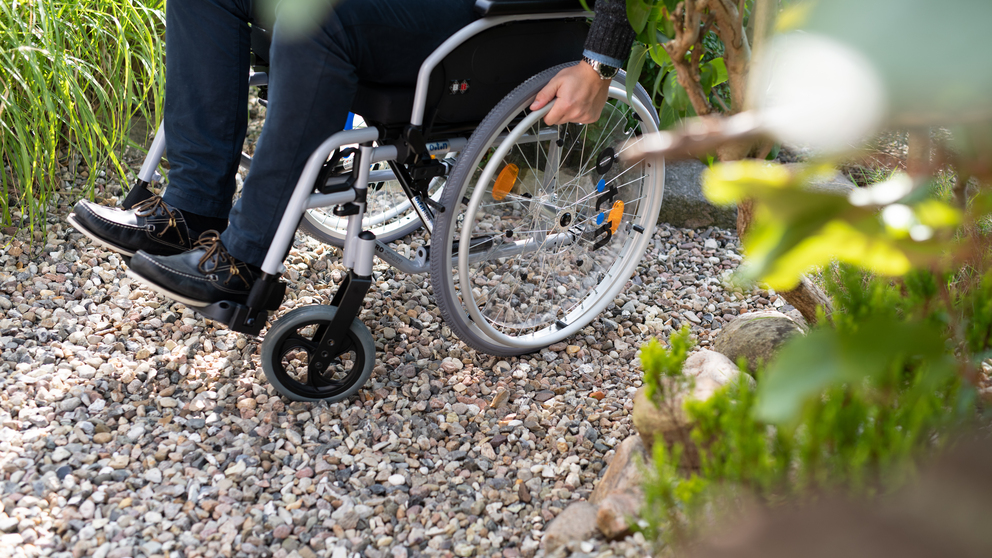 Wheelchair moving across gravel with ACO ground reinforcement